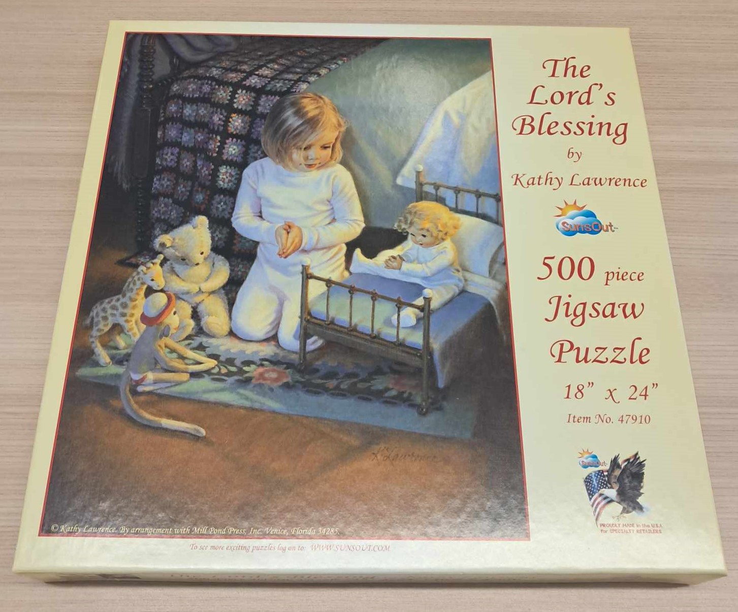 Puzzle cover showing a girl praying next to a crib with stuffed toys next to her.