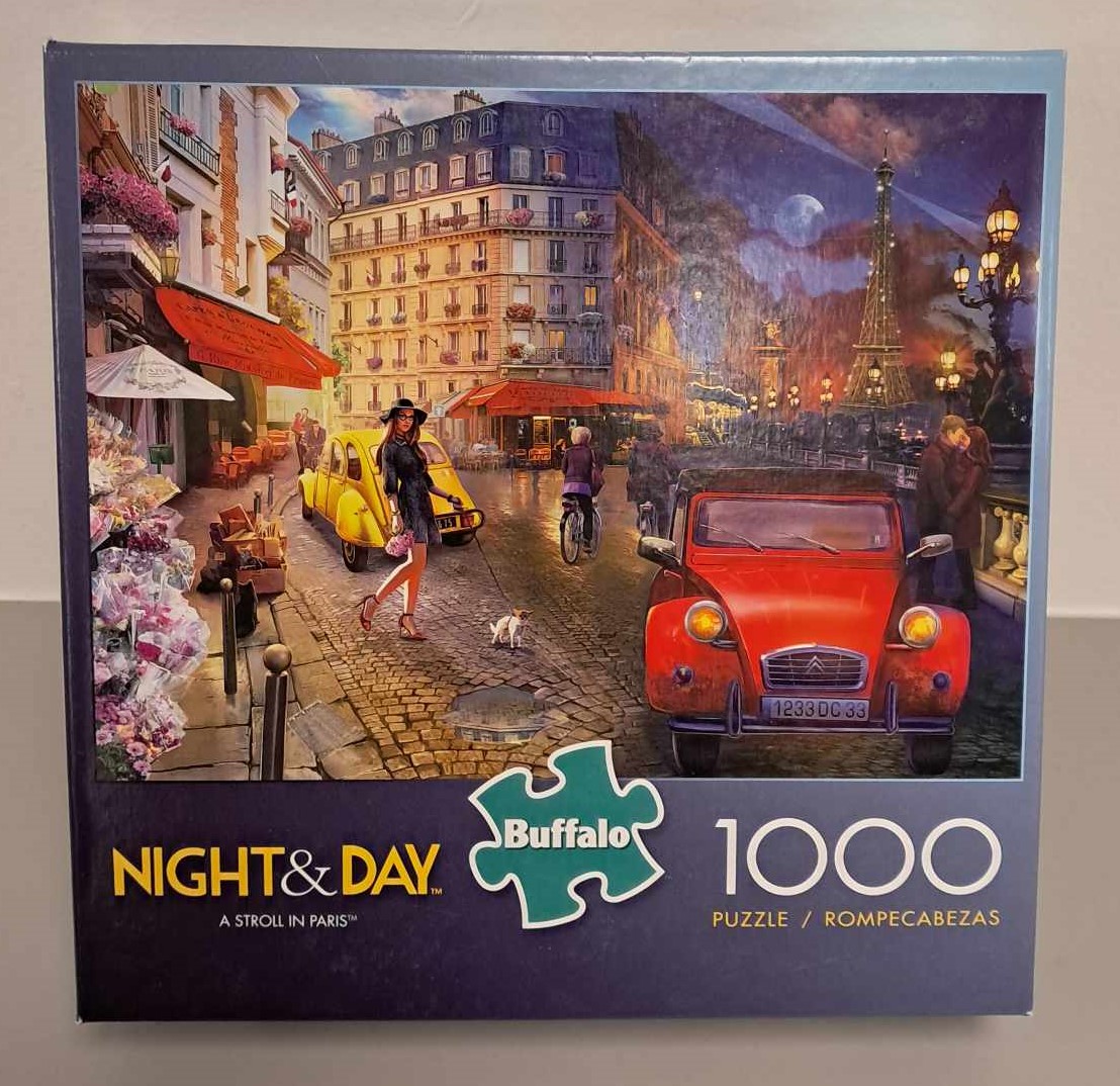 Image of a puzzle cover showing an artistic rendering of Paris France with one half set in daylight and the other half set during the night.