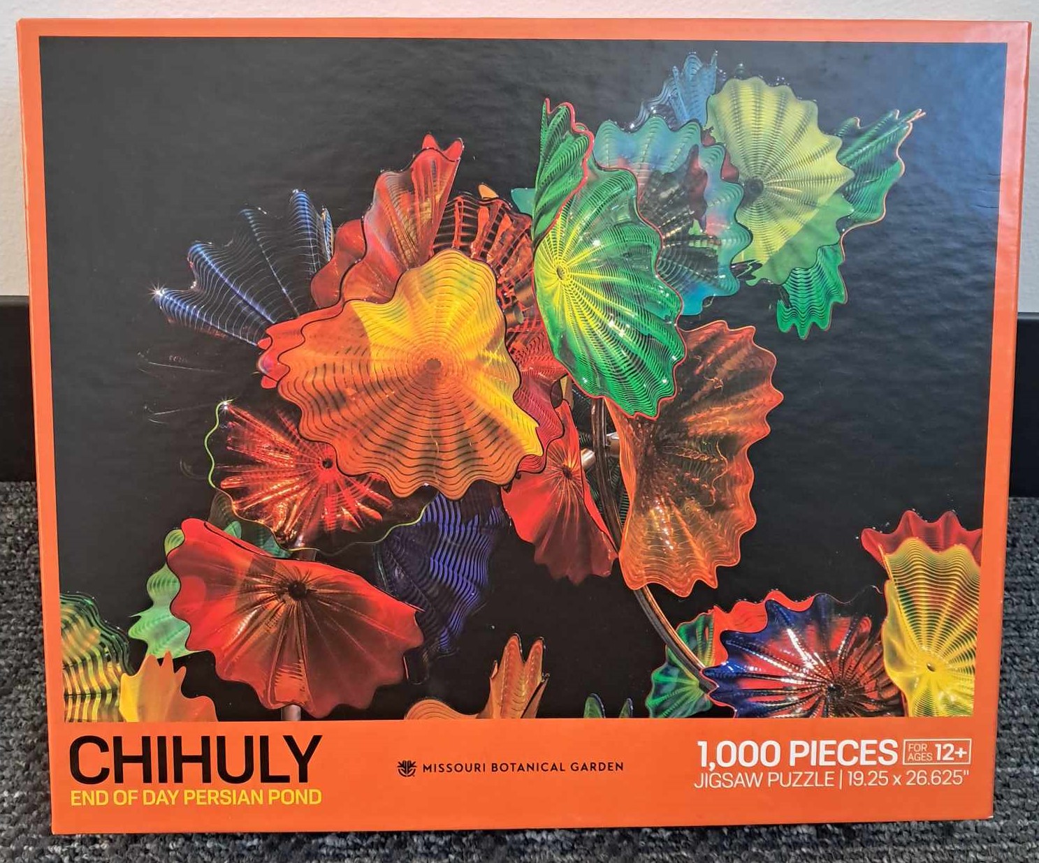 Image of a puzzle cover with a photograph of sculpture made by Dale Chihuly where glass has been crafted to look like flowers.