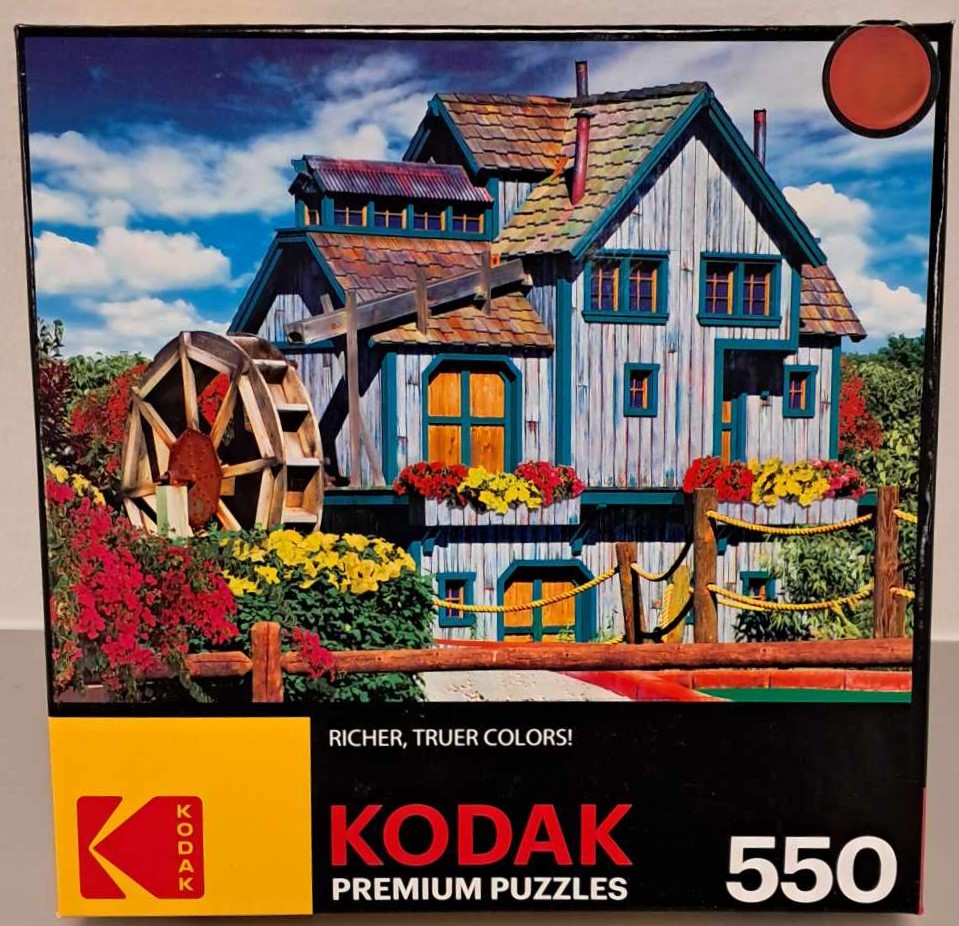 Puzzle cover showing an image of a blue barn with a water wheel.