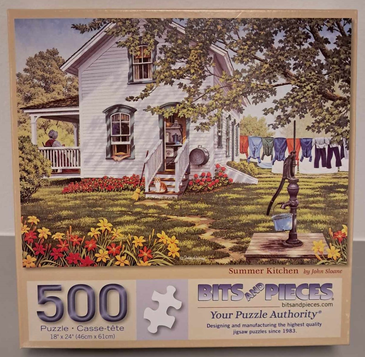 Puzzle cover of an artistic drawing of a house with the door open leading to a patron, a woman is sitting outside on the porch and clothes are hanging out to dry on a clothes line.