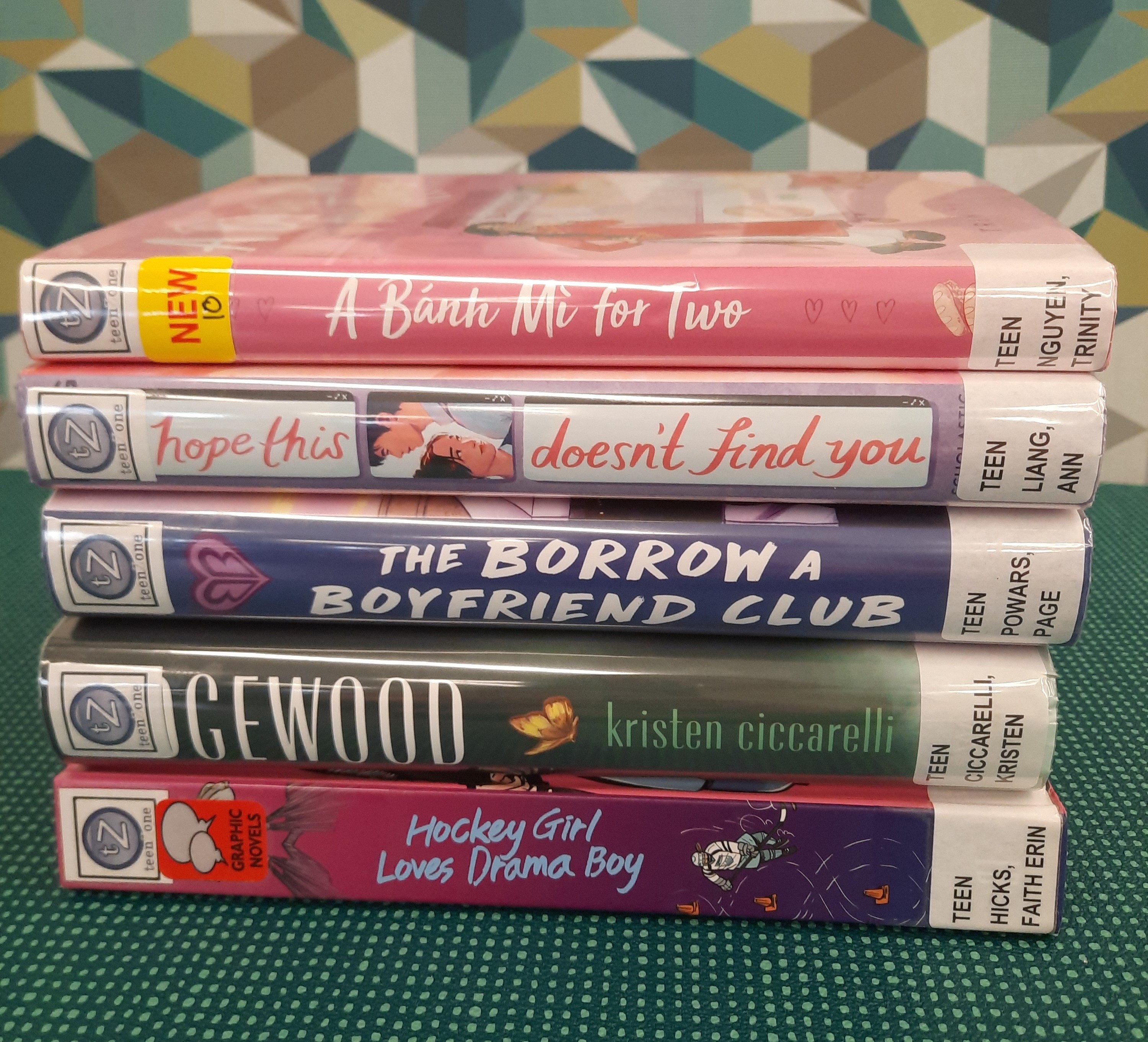 Book stack showing the following titles: "A Banth Mi for Two," "I Hope this doesn't find you," "The Borrow a Boyfriend club," "Edgewood," and "Hockey Girl Loves Drama Boy"