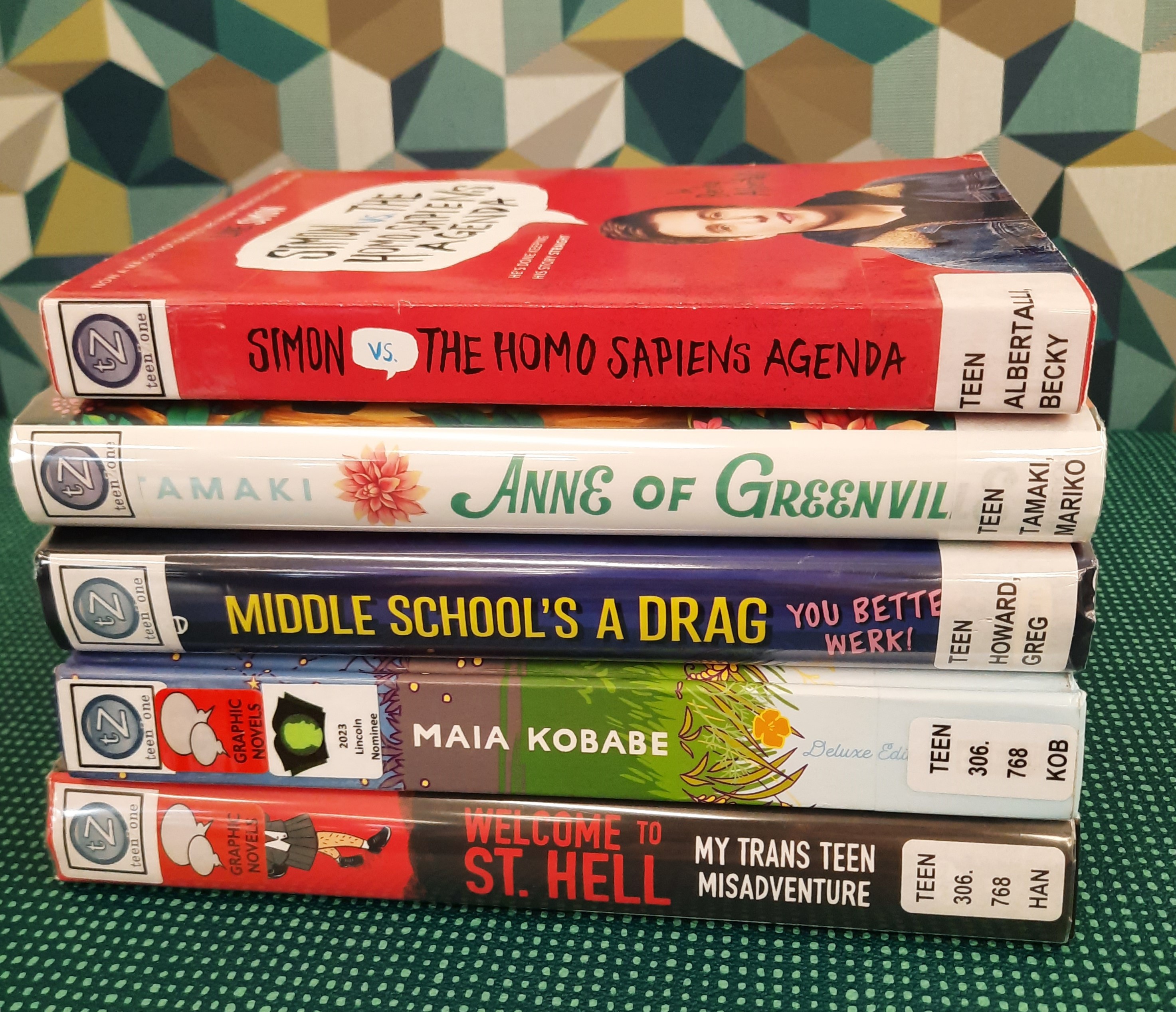 Book Stack showing the following titles: "Simon vs. The Homosapiens agenda," Anne of Greenville," "Middle School's a Drag," "Gender Queer," and "Welcome to St. Hell"